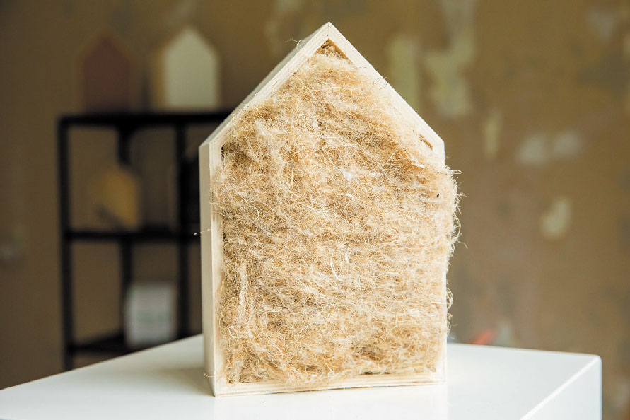 Isolatiemateriaal in de vorm van een huismodel toont natuurlijke isolatieoptie voor woningverduurzaming.