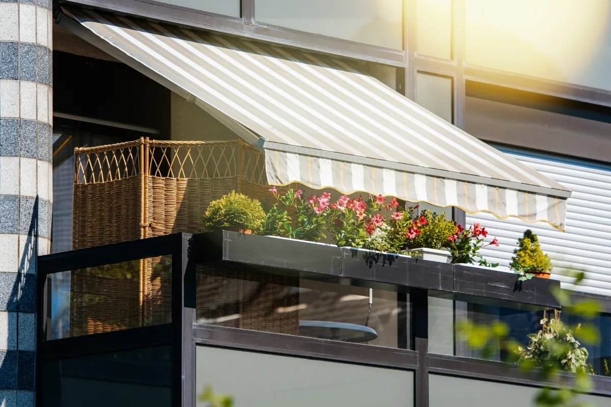 Zonwering op balkon met plantenbakken die warmte binnen huis verminderen en energie besparen.