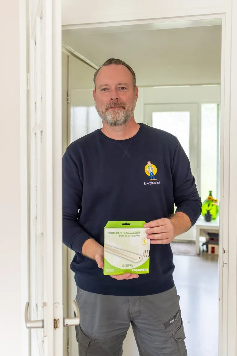 Gratis gesprek met energiecoach waarbij advies wordt gegeven over energiebesparing aan tafel met laptop en documenten.