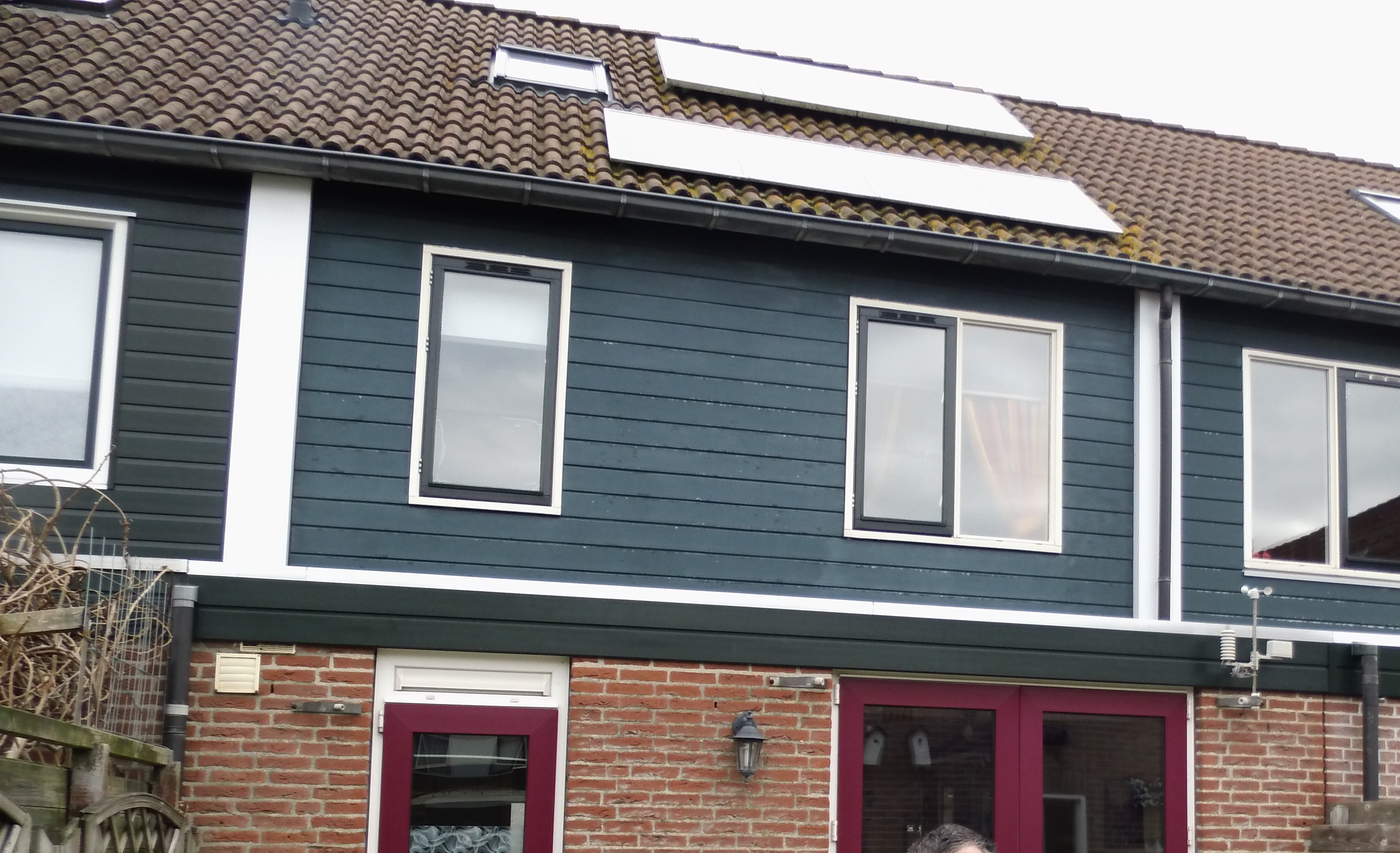 Peter Plugboer voor een huis met zonnepanelen op het dak en vernieuwde gevelbekleding.